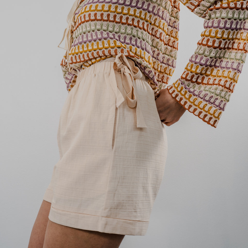 Side view of the heirloom crochet tie shorts showing the textured knit pattern and comfortable fit. Bows on the side.