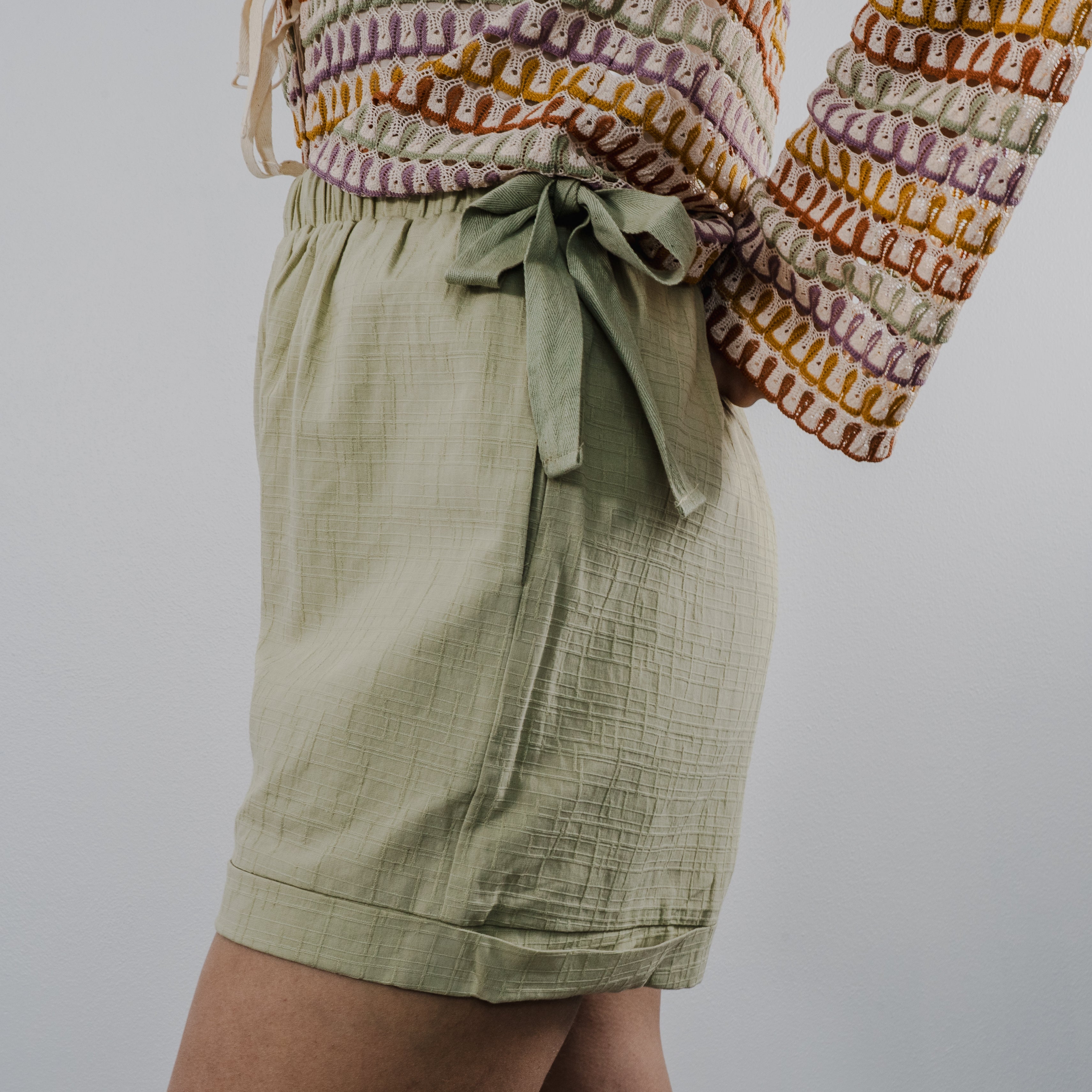 Side view of the heirloom crochet tie shorts showing the textured knit pattern and comfortable fit. Bows on the side.