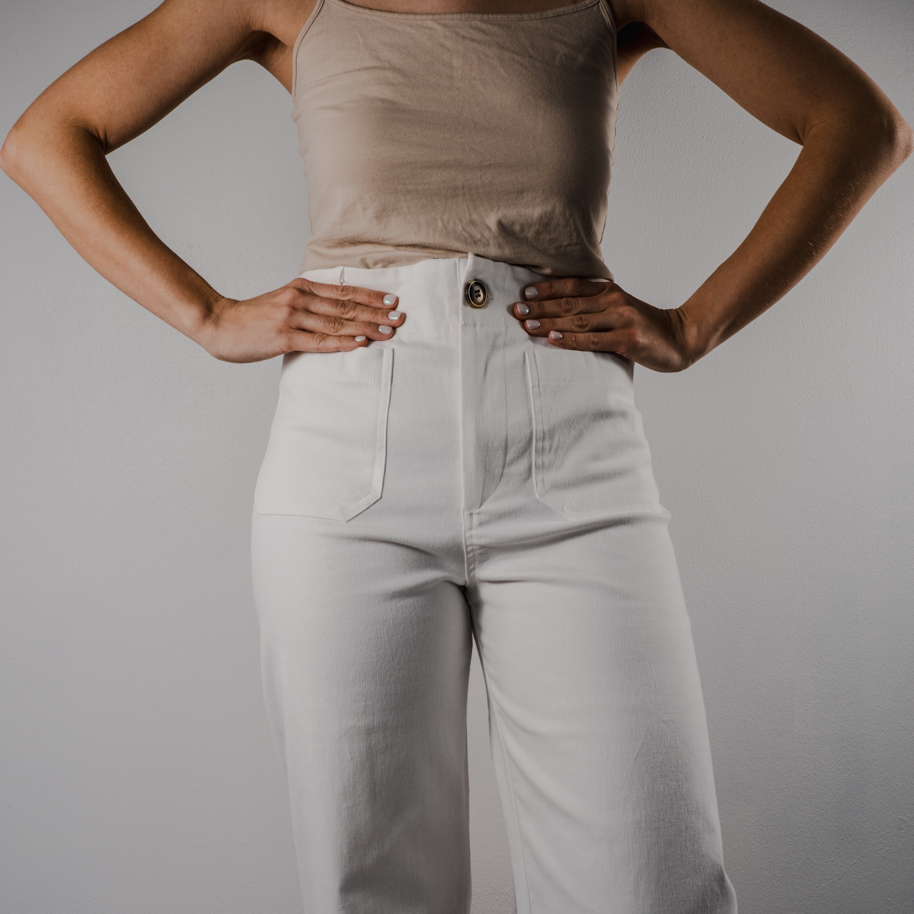Close-up of the comfortable elastic waistband on the Gentle Bloom scalloped wide-leg pants. Shows a tortoiseshell button and pockets.