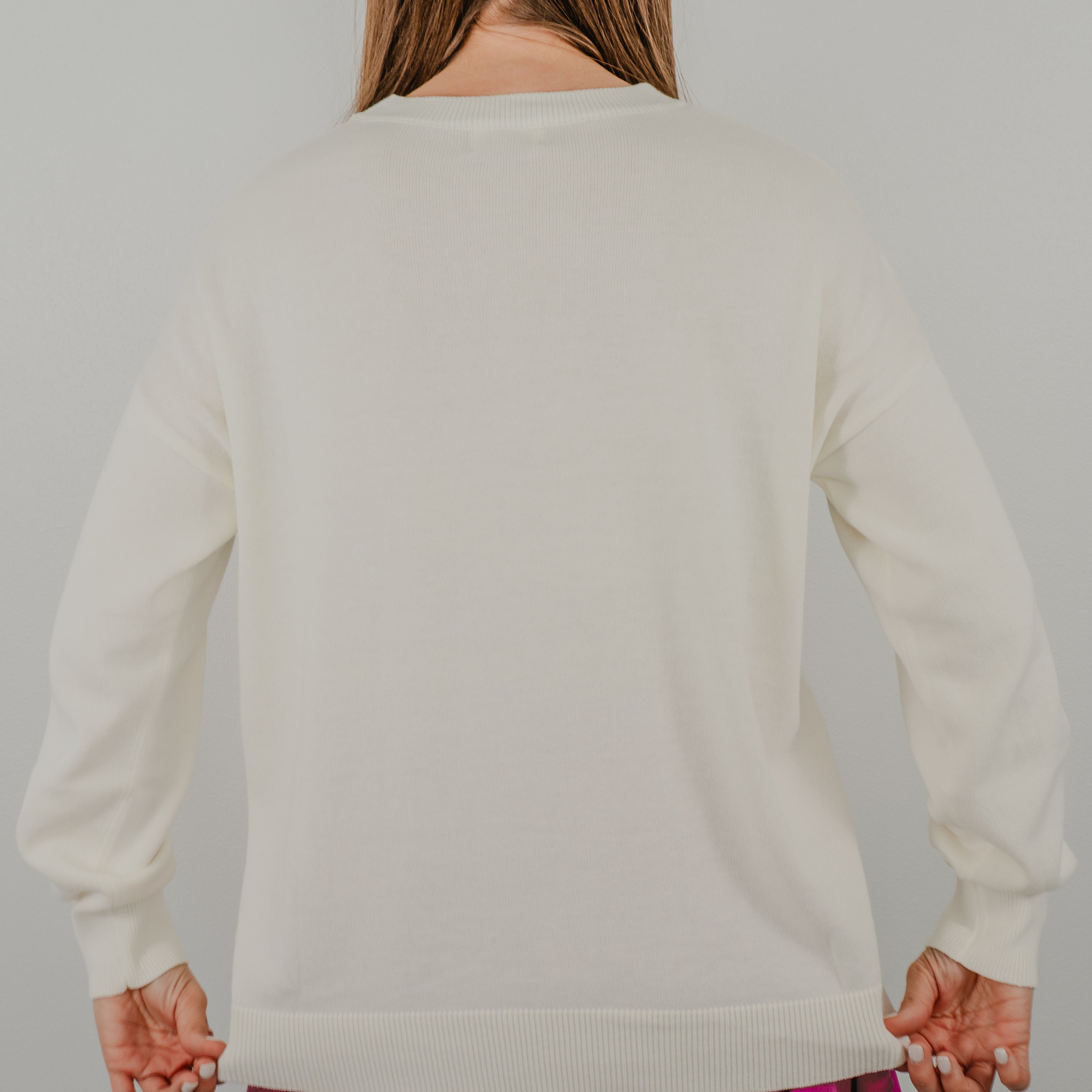 Back view of the sweater to show detail of the soft, ribbed knit cuffs and solid color on the Pickleball Club crewneck sweater.