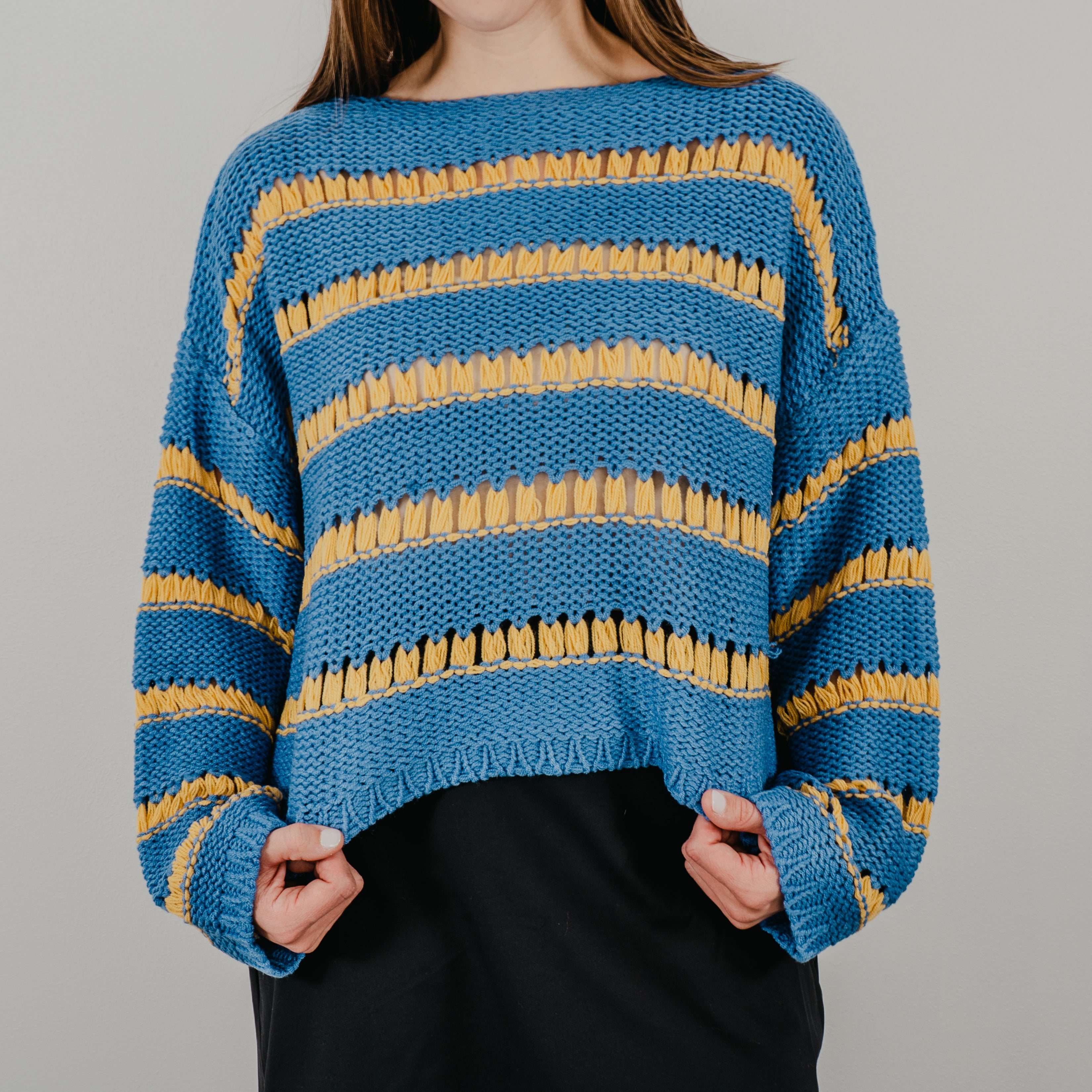 Bold blue and gold striped knit sweater with an oversized boxy silhouette and dropped shoulders.