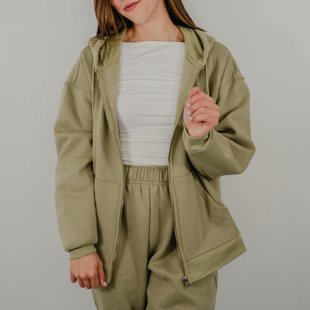 Oversized zip-up hoodie in a premium heavy-weight fleece, featuring a silver front zipper and deep side pockets.